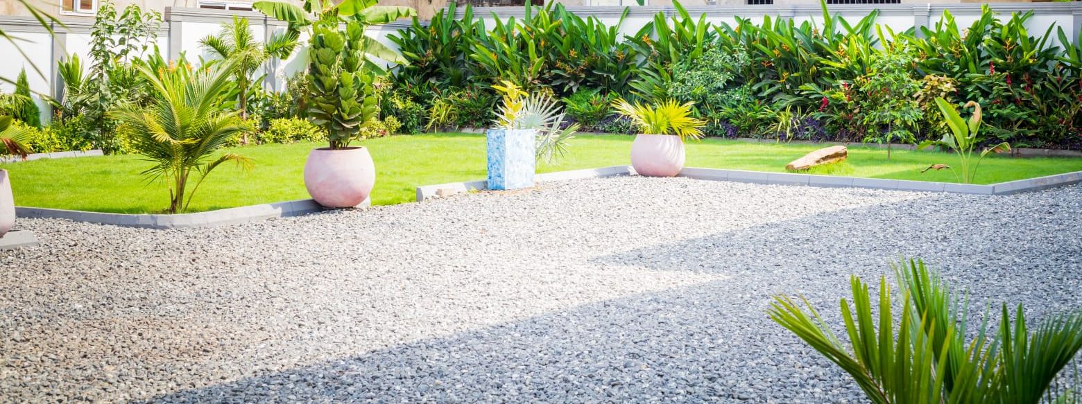 Lawn, potted palms and the gravel court inside the grounds