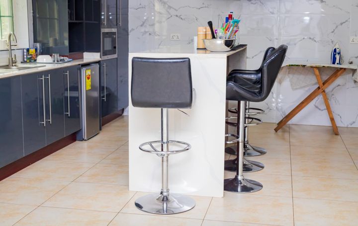 Kitchen island with bar stools and marble walls
